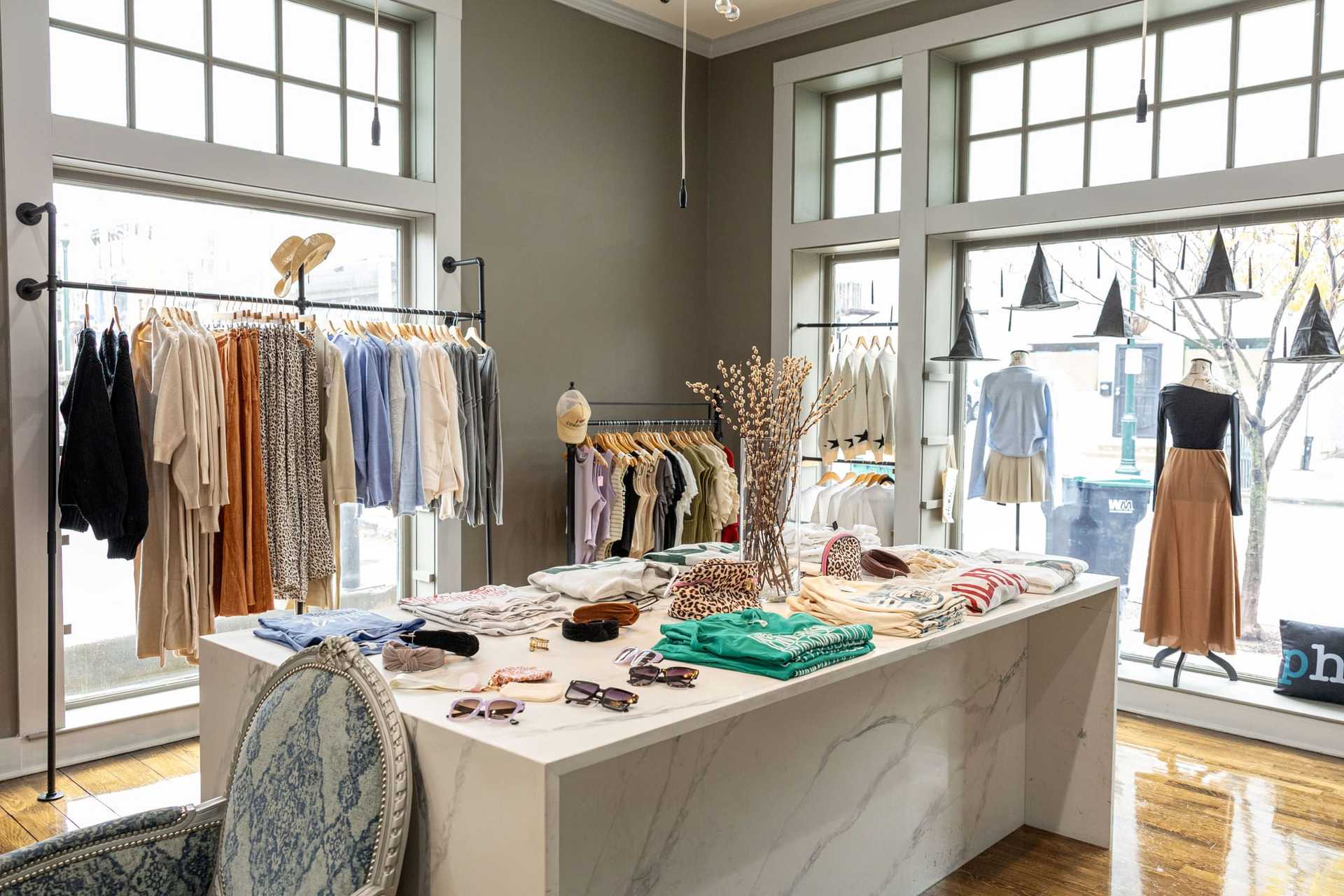 Clothing boutique with stylish outfits, accessories, and modern decor.